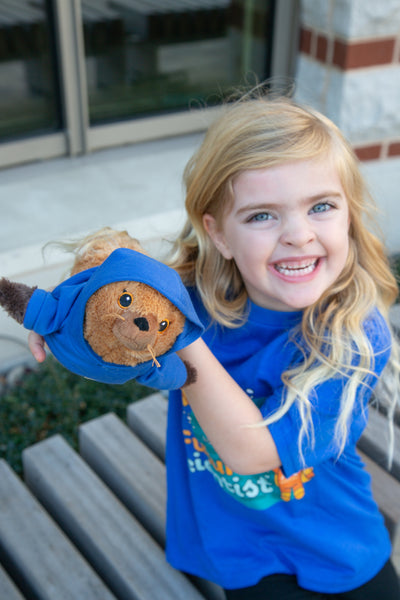 A girl holds the AGU23 mascot, a stuffed sea lion toy