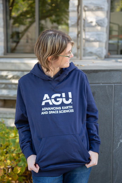 Woman wears a navy blue hoodie with the AGU logo printed in white
