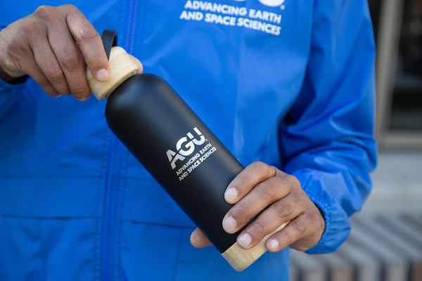 Stainless steel water bottle with the AGU logo on a black background