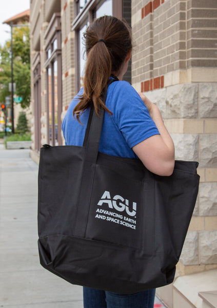 A woman holds the AGU zippered tote