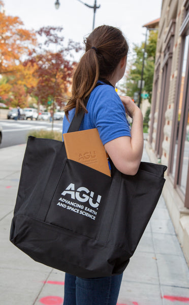 A woman holds the AGU tote