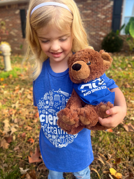 A girl holds a plush bear toy