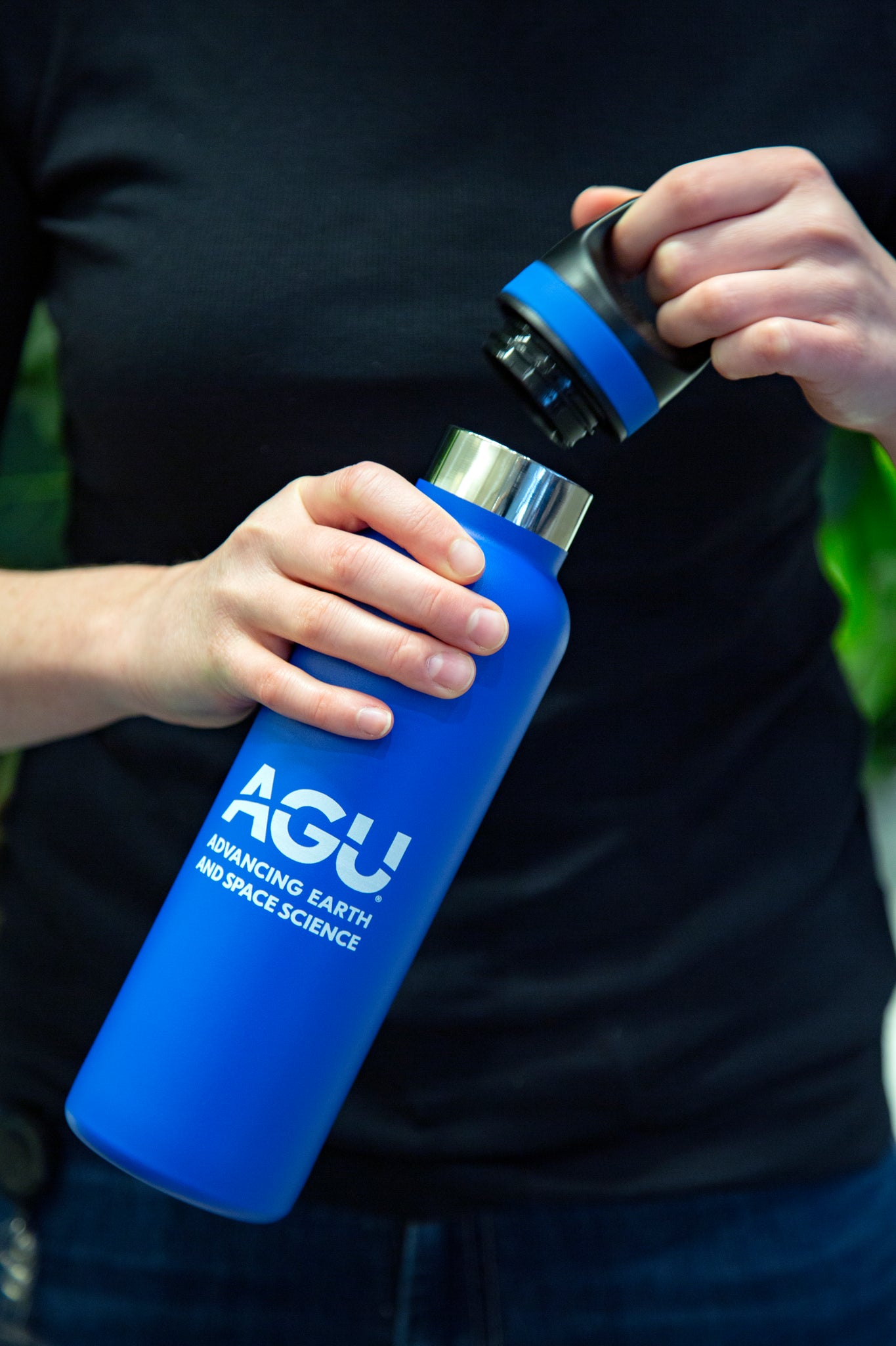 A person holds the AGU water bottle